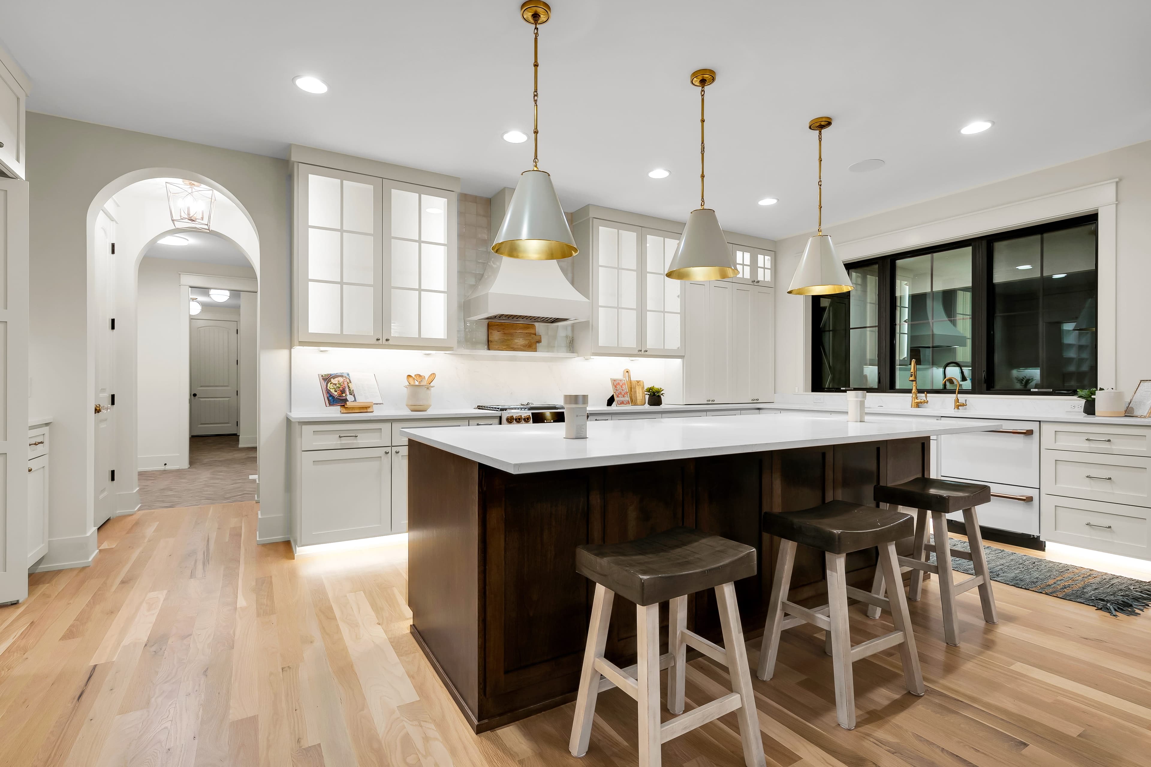 Kitchen island with barstool seating and arched hallway