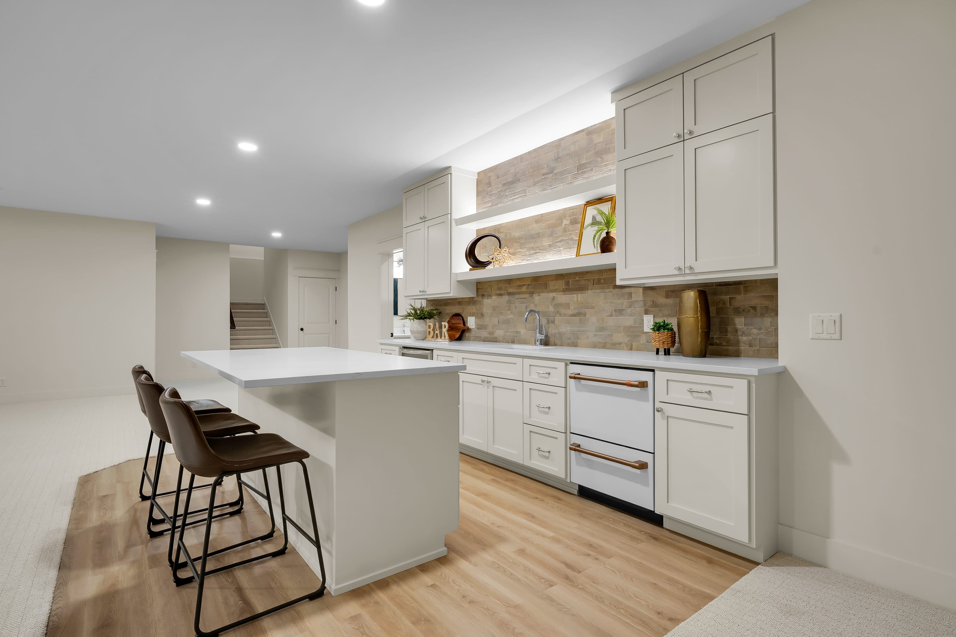 Lower-level bar lit by recessed, shelf and undercabinet lighting